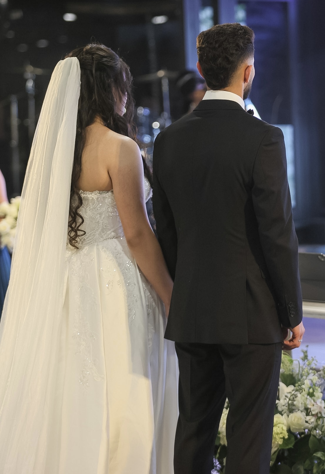 Bride and groom holding hands at the altar