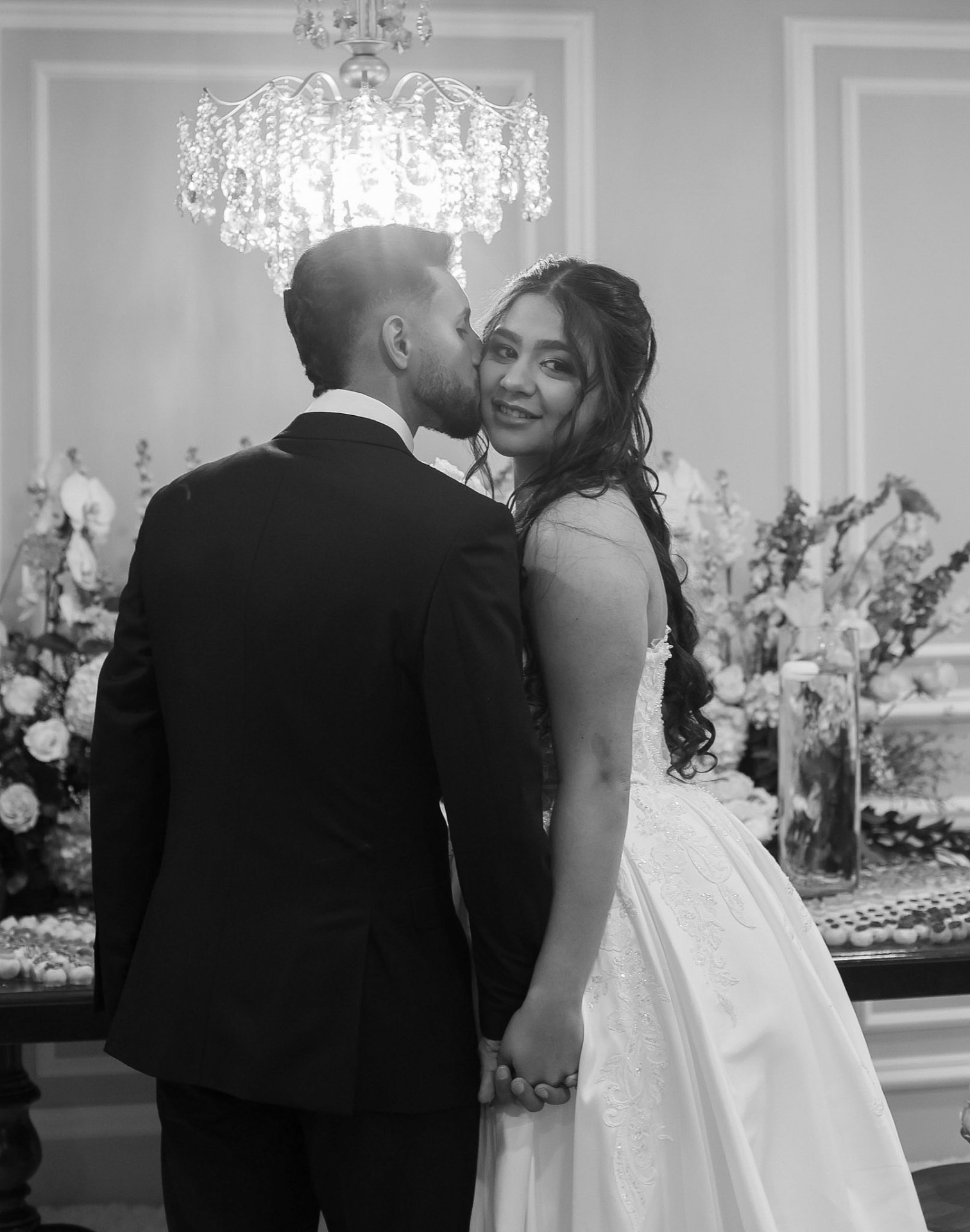 A quiet kiss beneath the chandelier